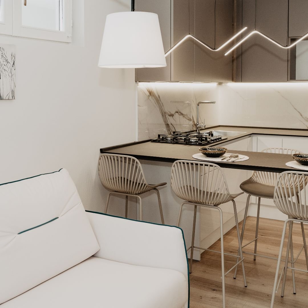 Cucina moderna ed elegante in un appartamento del Residence Elite, con piano snack, sgabelli di design e illuminazione a LED.